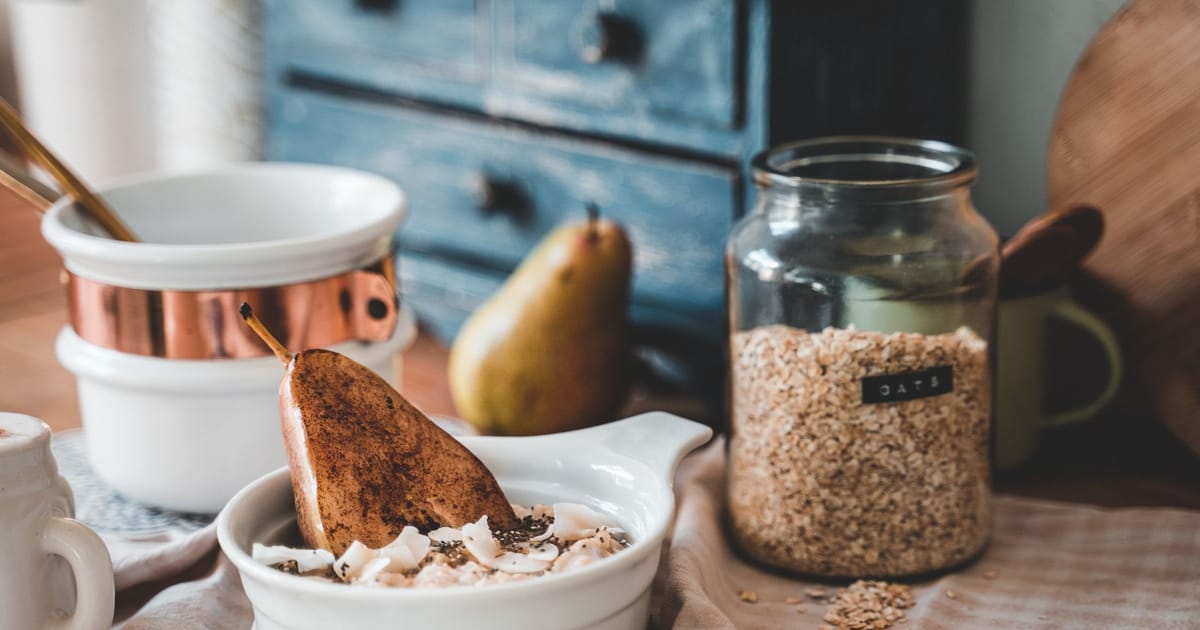 Tigela de cerâmica branca com granola, sementes e frutas vermelhas vista de cima